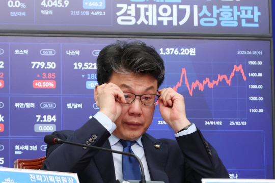 진성준 더불어민주당 정책위의장이 지난 6월18일 국회 본청에서 열린 당 최고위원회의에서 참석자들의 발언을 들으며 안경을 고쳐쓰고 있다. <연합뉴스 사진>